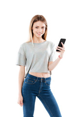 Portrait of a happy girl standing and holding mobile phone