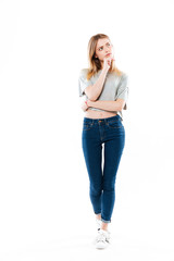 Full length portrait of a young thoughtful woman looking away