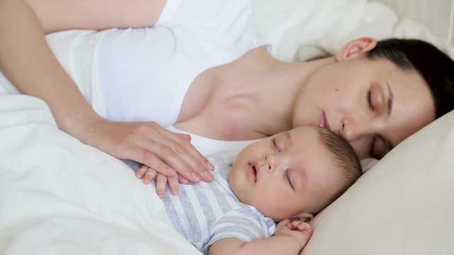 mom and son newborn sleeping in bed