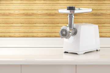 Modern electric meat grinder on a table in the kitchen room interior