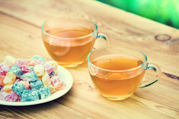 Two cup of green tea decorated with turkish delight on wooden table