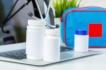 Obraz premium Stethoscope, laptop and pills on the white table