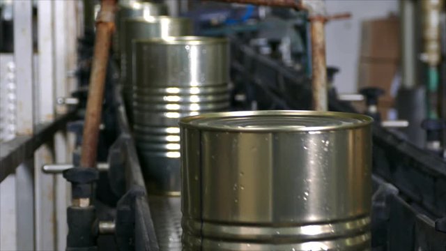 Packing food in metal cans, transporting with conveyor in warehouse