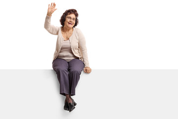 Mature woman sitting on a panel and waving