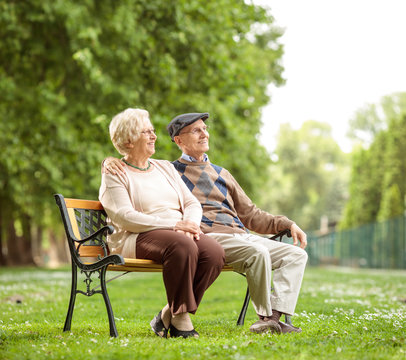 Senior Couple Sitting On A Bench In The Park