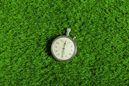 Silver chronometer on green grass
