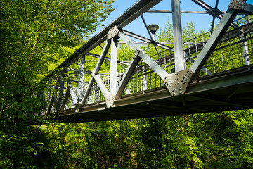 Metal bridge over river in country forest