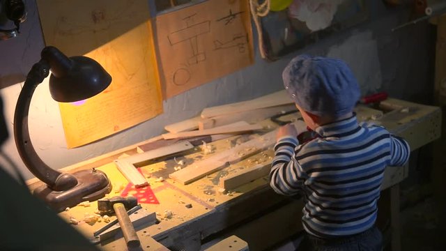 Boy working in home carpenter workroom