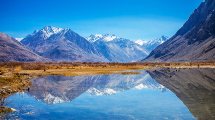 Reflections of Snow mountains in the lake in Diskit, Nubra, Leh, India