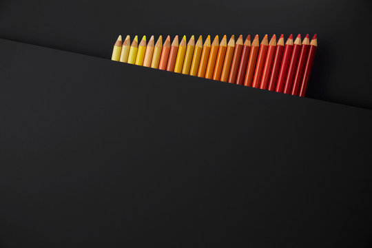 Colour pencils isolated on black background close up