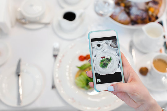 Woman's hand smartphone take pictures of breakfast