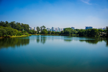 Fototapeta na wymiar Ibirapuera Park, Sao Paulo, Brazil - Panoramic view of the lake with buildings in the background.