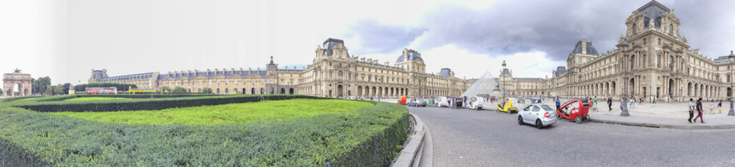 Fototapeta na wymiar PARIS - JUNE 2014: Tourists walk near Louvre. Paris attracts 30 million tourists annually