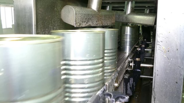 Packing food in metal cans, transporting with conveyor in warehouse