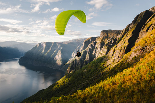 Paraglider silhouette flying over Aurlandfjord, Norway