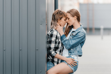 Beautiful young lesbian couple hugging and kissing outdoors
