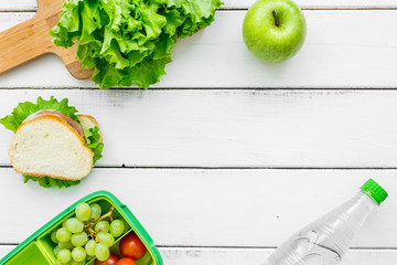 school lunch set with apple and vegetables in lunchbox background top view mock up