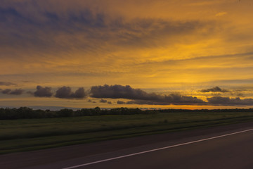 Sunset in field. View from car window in motion.