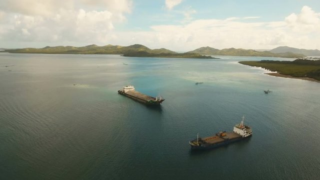 Cargo and passenger port with barges and cargo ships on tropical island. Aerial view:passenger ferry terminal Dapa city .Ferries for transport vehicles and passengers in the port. Philippines, Siargao