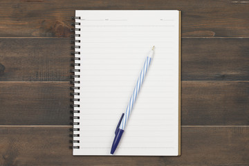 pen with notebook on wooden background