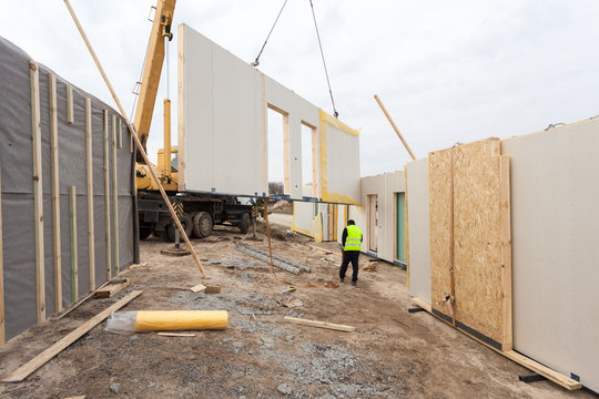 Roofer builder workers with crane installing structural Insulated Panels SIP. Building new frame energy-efficient house