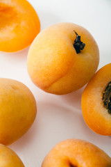 Fresh apricots whole and sliced on white background. Copy space