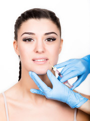 Beauty injection by doctor in blue gloves. Young woman in beauty salon