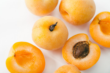 Fresh apricots whole and sliced on white background. Copy space