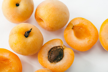 Fresh apricots whole and sliced on white background. Copy space