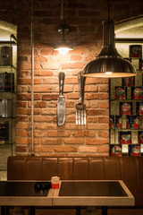 Decoratd detail of restaurant interior, ceiling lamp table and brick wall