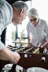 Senior business colleagues playing foosball at office