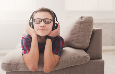Teenage boy enjoying music in headphones at home