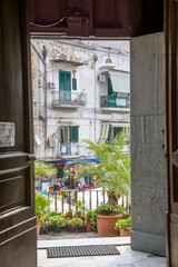 Old residential building seen from an open door of a church