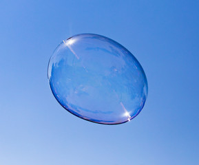 Big soap bubble against the blue sky