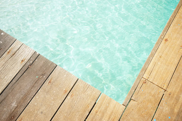 Fototapeta na wymiar Close up wooden jetty with crystal clear and turquoise sea water of the tropical sea . Top angle view .Rawa island , Malaysia .