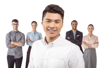 portrait of asian businessman standing in front of his colleagues isolated on white