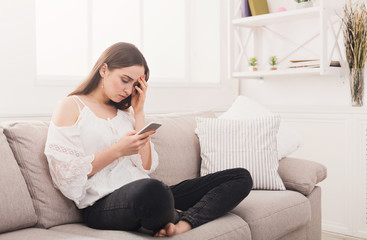 Young anxious woman messaging on smartphone