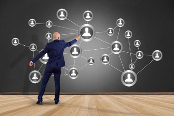 Businessman in front of a wall with a business network connection - business concept