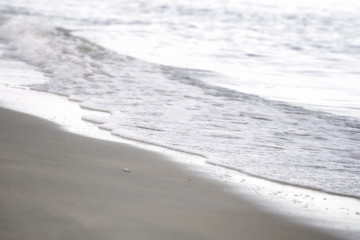 Soft Wave Of Sea  On Sand Beach. Background. Selective focus.