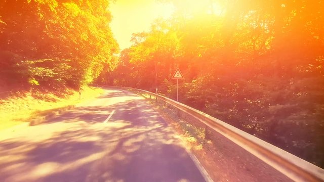 POV footage of driving down a rural road at sunset
