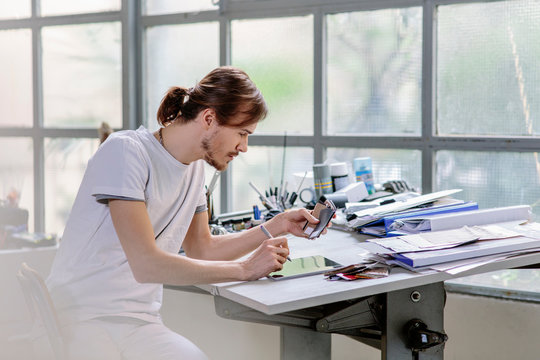 Man at drawing board using digital tablet