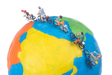 miniature people riding bicycle around the globe isolated on white background