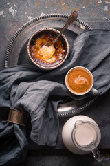 Creme brulee with cup of coffee on the stone background vertical