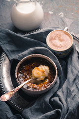 Creme brulee with cup of coffee on the stone background