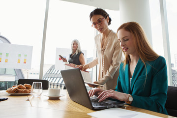 Businesswomen preparing presentation in meeting room