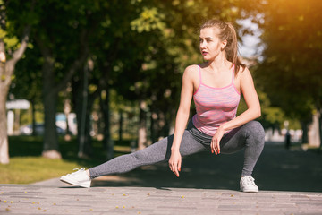 Fit fitness woman doing stretching exercises outdoors at park