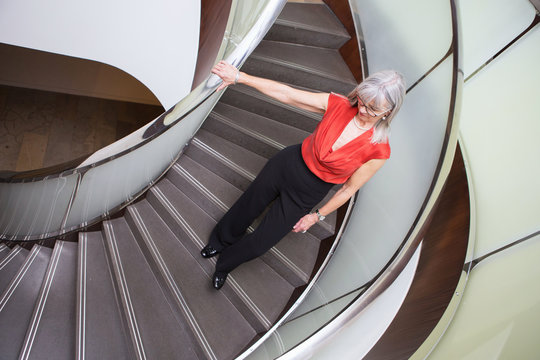 Businesswoman going down spiral staircases