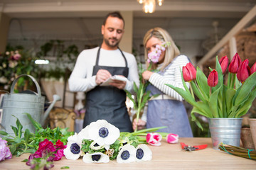 Two florists in flower shop, preparing flower order