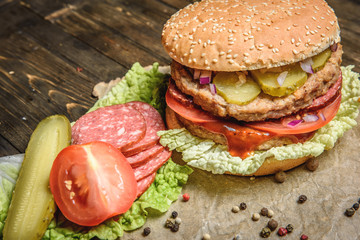 Burger with salami and vegetables