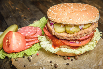 Burger with salami and vegetables
